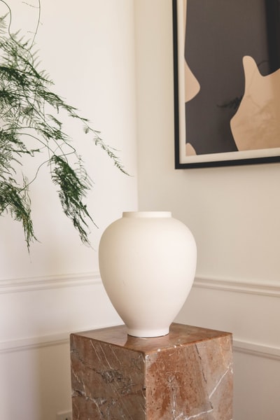 棕色木桌上的白色陶瓷花瓶